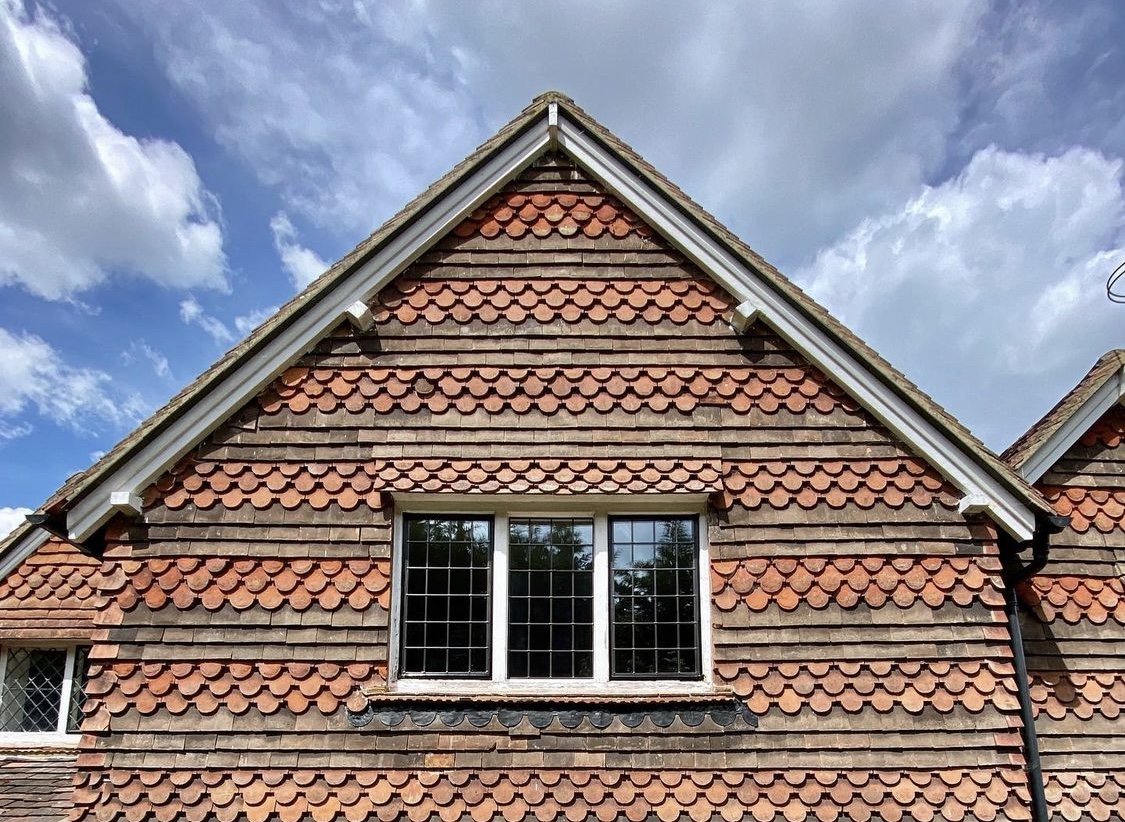 Close up of a wooden window frame on the side of a red brick house.