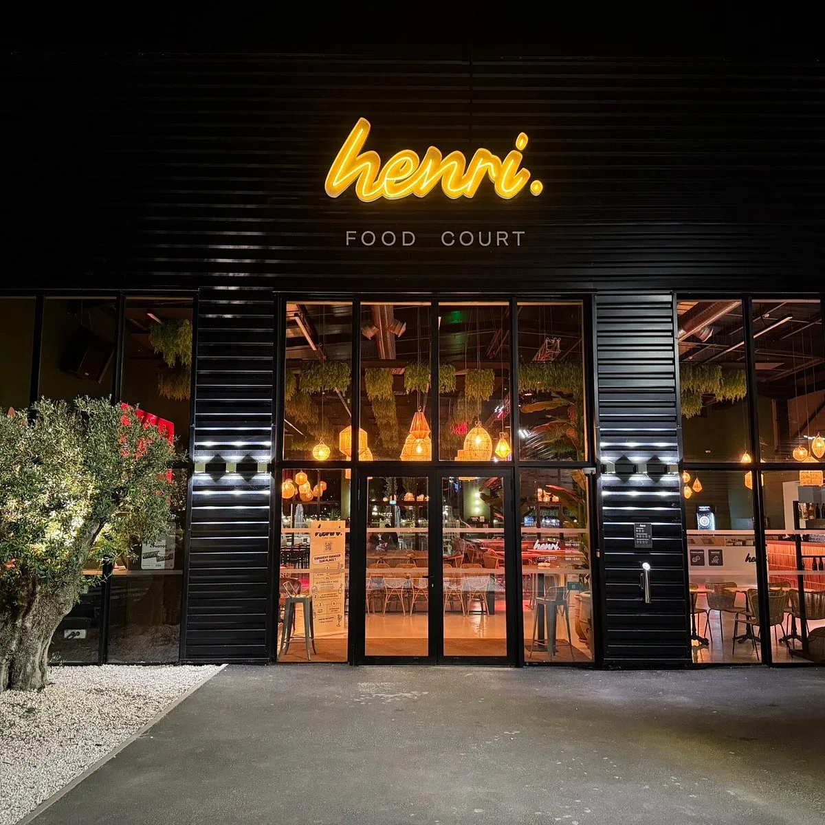 Façade du Henri Food Court à Lescar de nuit avec son enseigne lumineuse