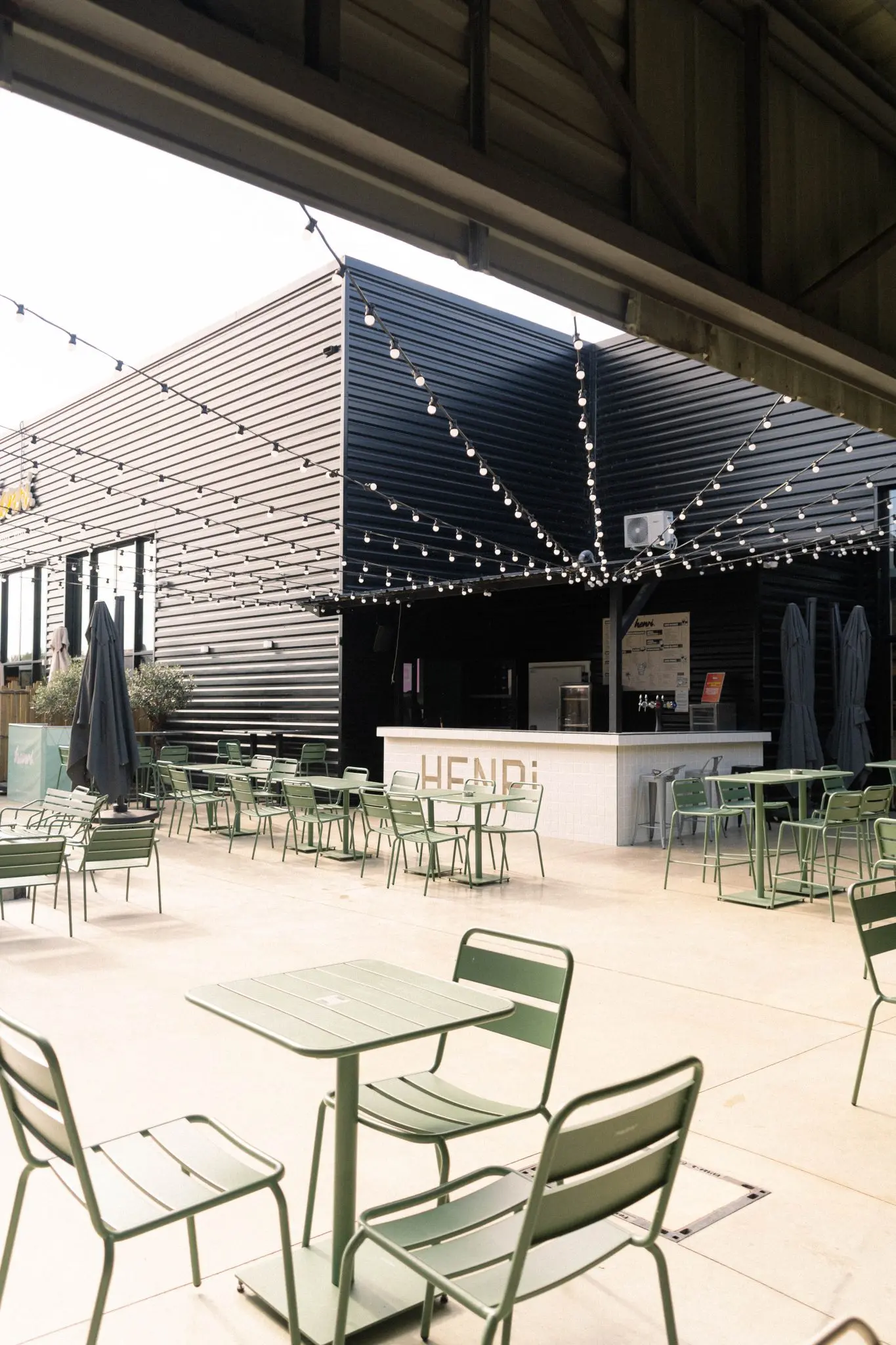 Terrasse extérieure du Henri Food Court à Lescar avec guirlandes lumineuses et boulodrome