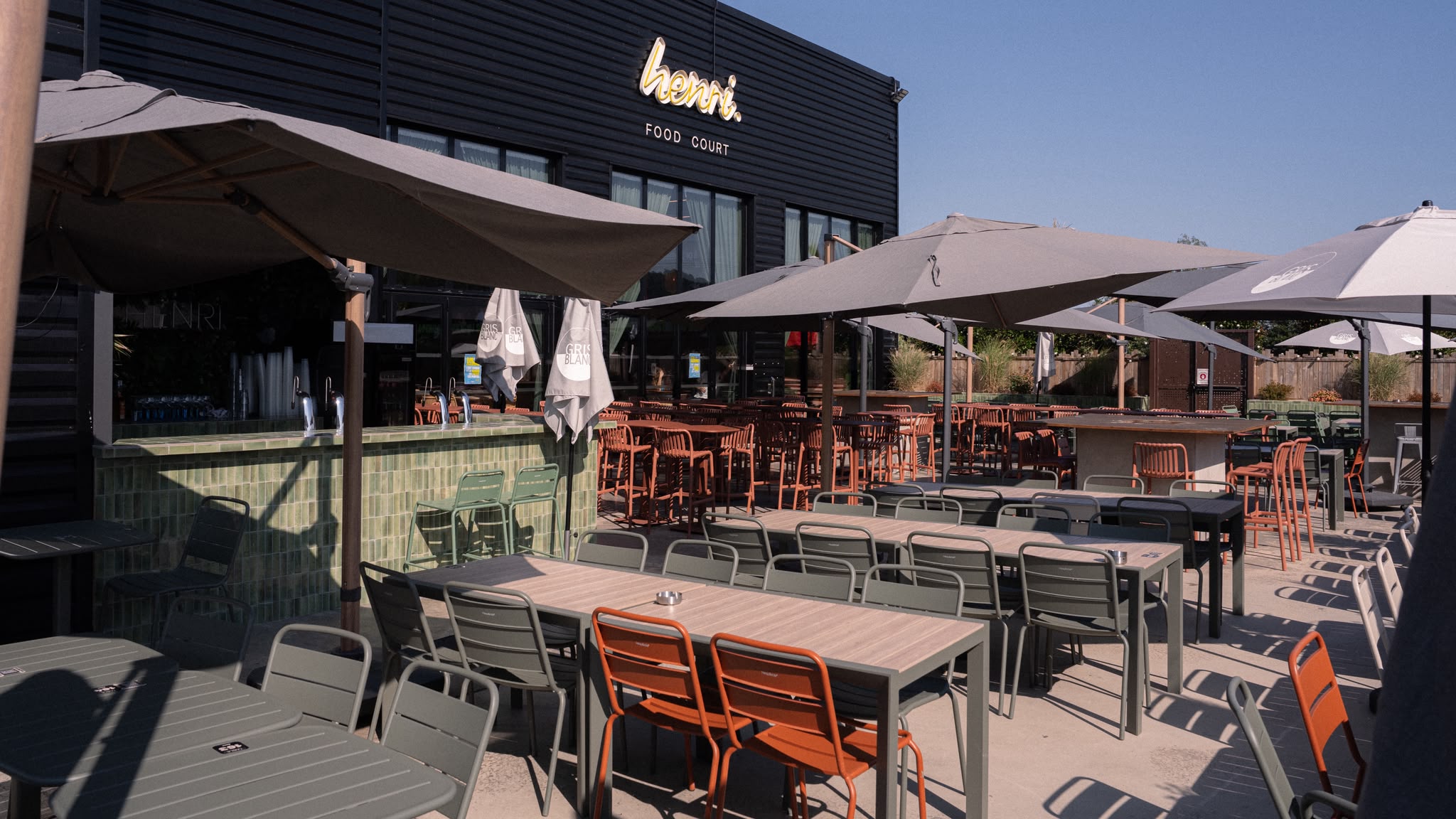 La terrasse Dolce Vita du Henri Food Court à Lescar, tables et parasols au soleil