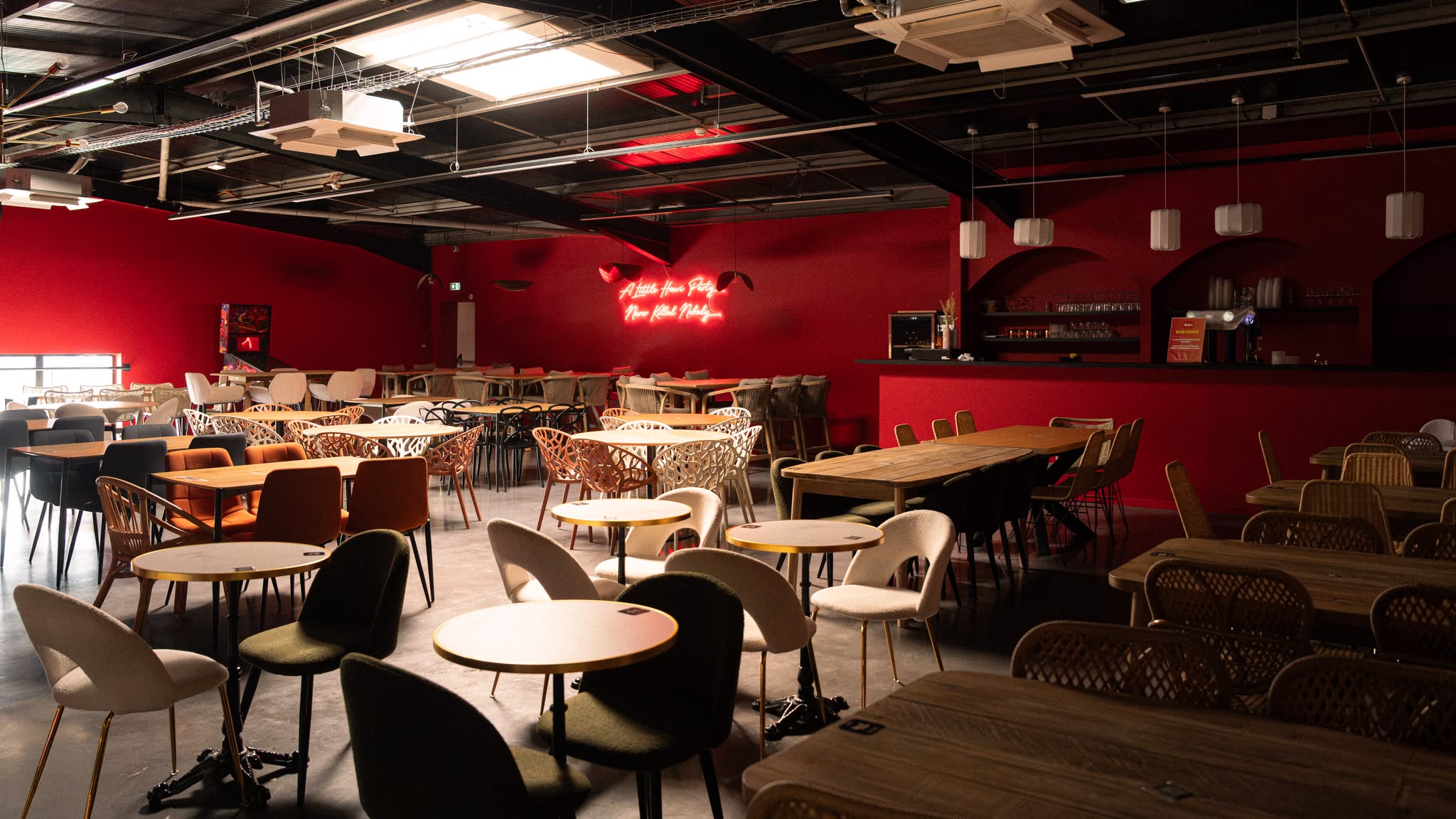 La Mezzanine du Henri Food Court, salle aux murs rouges avec bar et néon