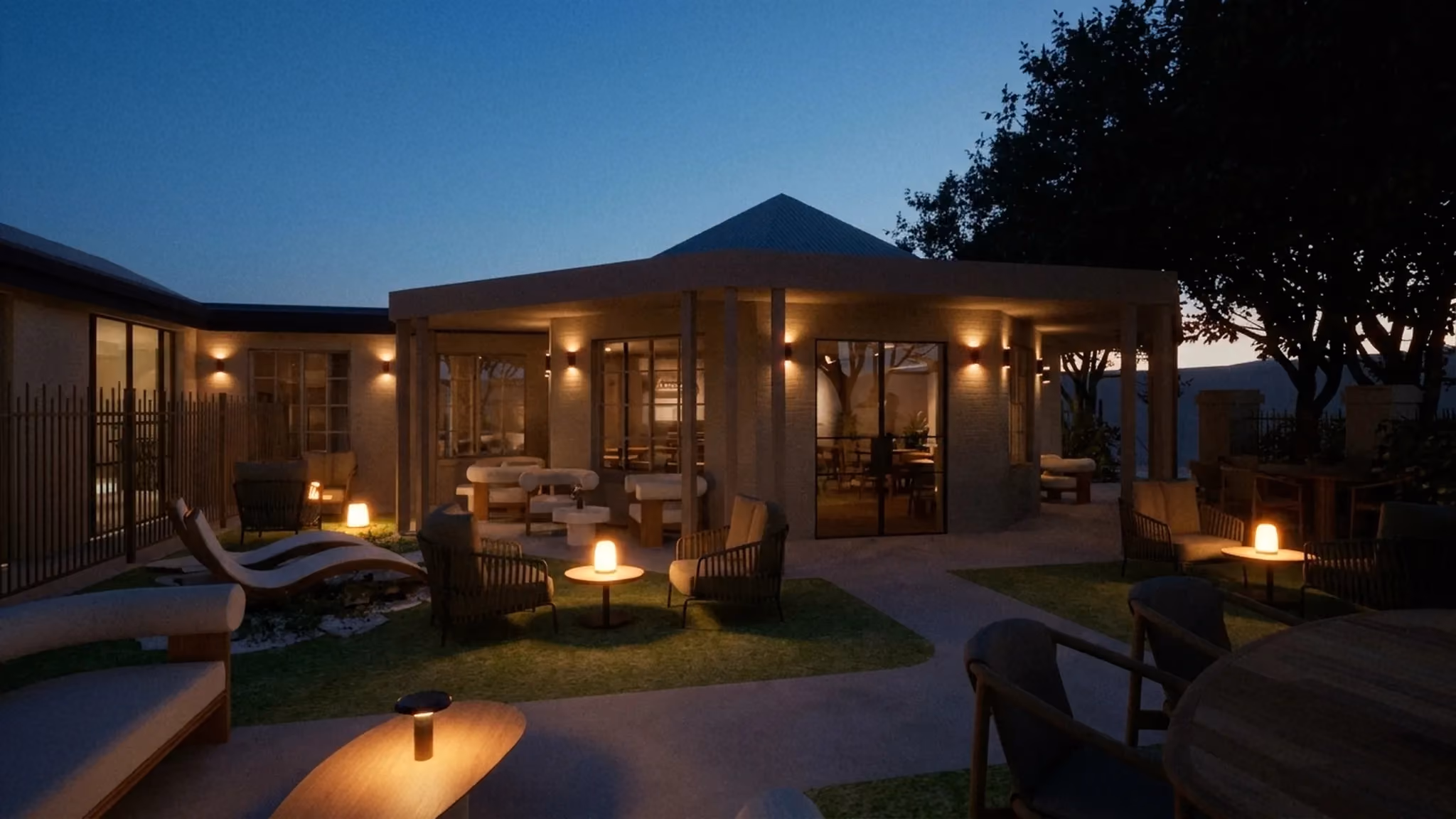 The VELA courtyard at dusk, with fire pits and warm lighting