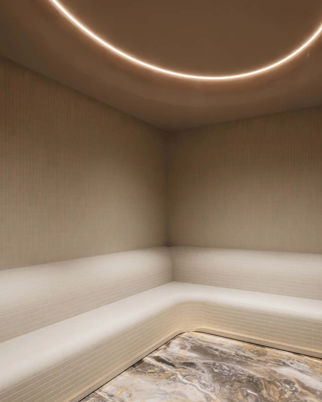 A softly lit bathing room at VELA, with a curved ceiling light above a stone-edged sunken pool