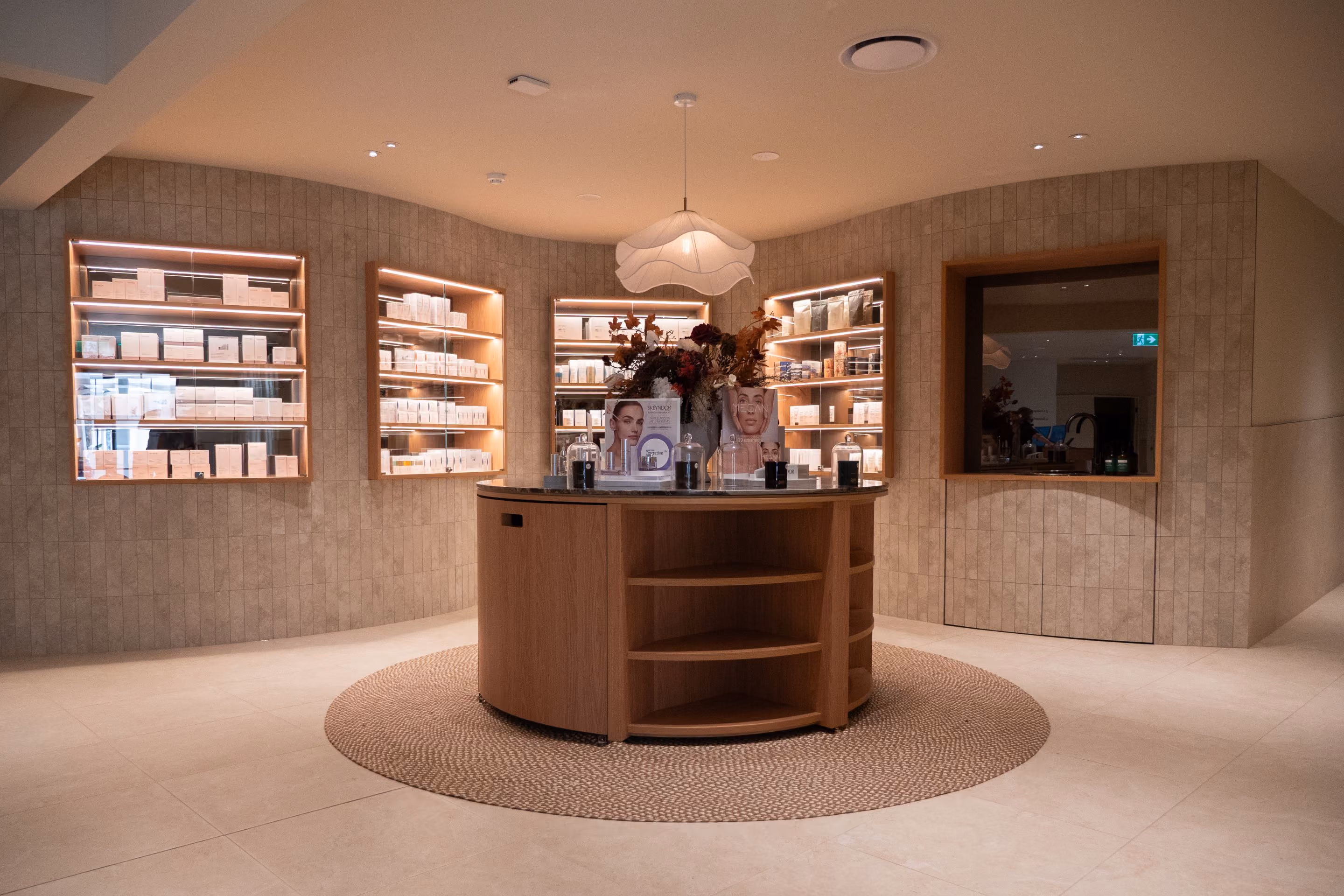 The VELA retail space, with curved timber shelving of skincare products under a vaulted ceiling