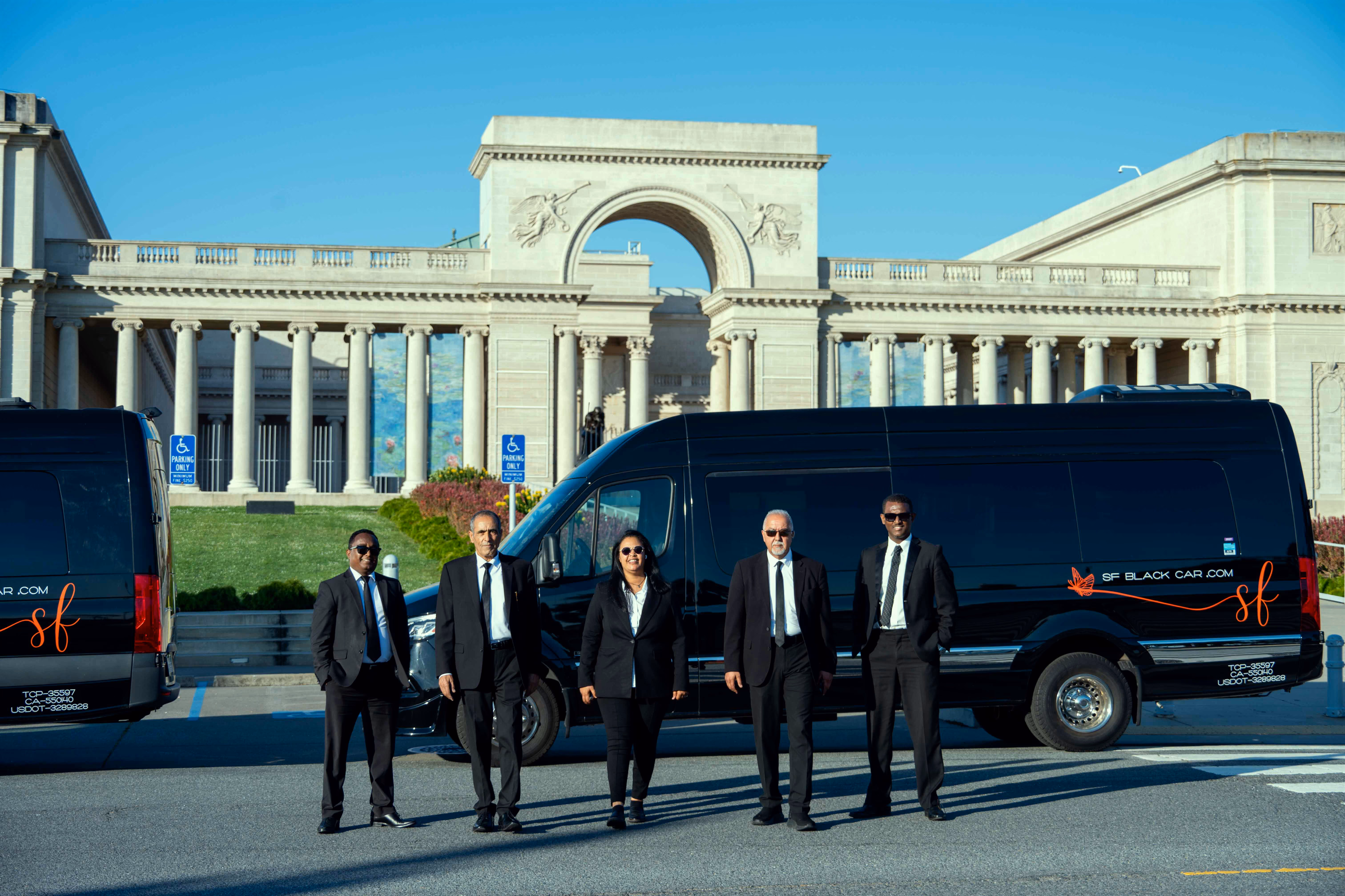 Chauffeurs lined up beside a black van with SF Black Car lettering before a classical arch and colonnade