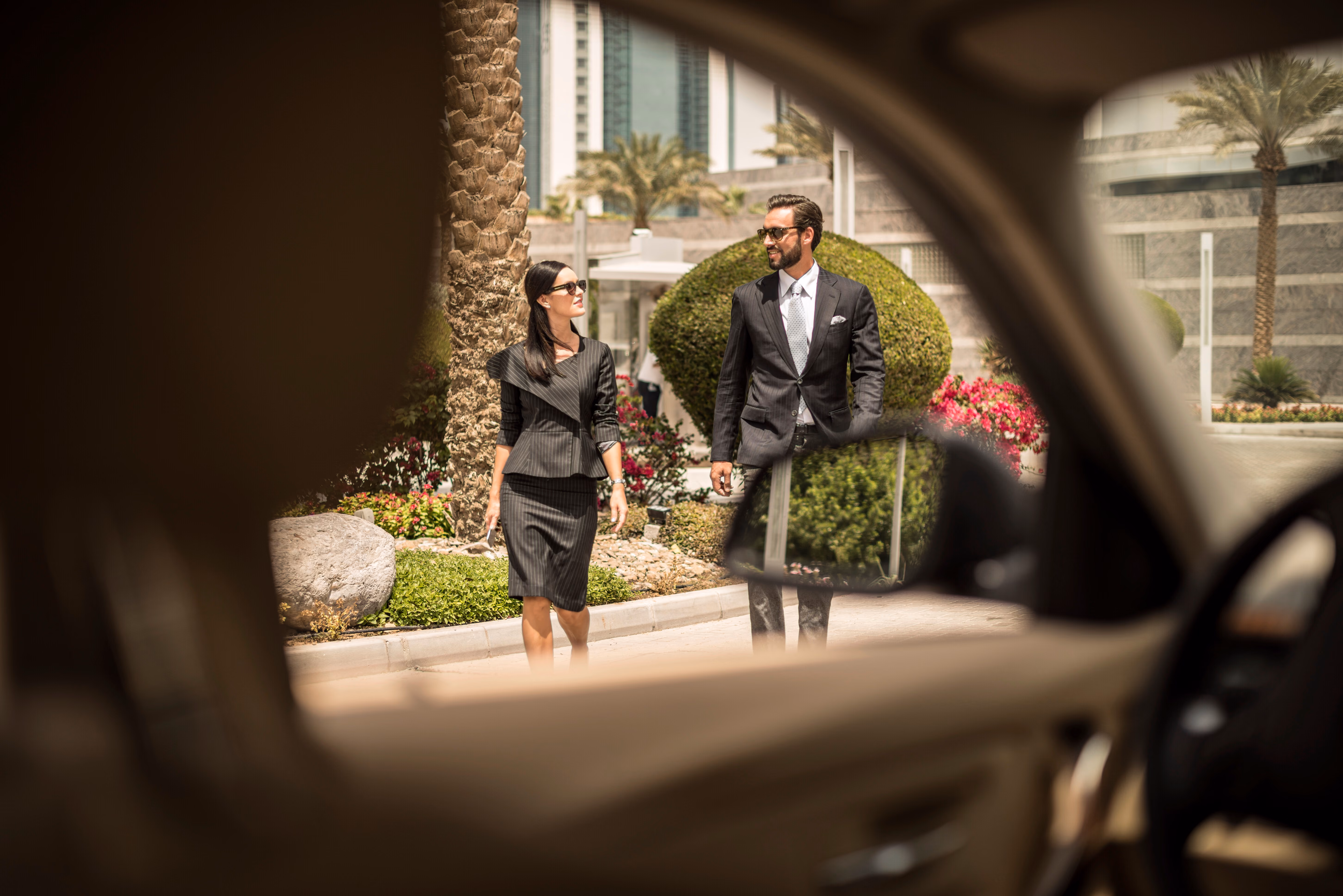 View from inside a car of a businesswoman and man walking outside