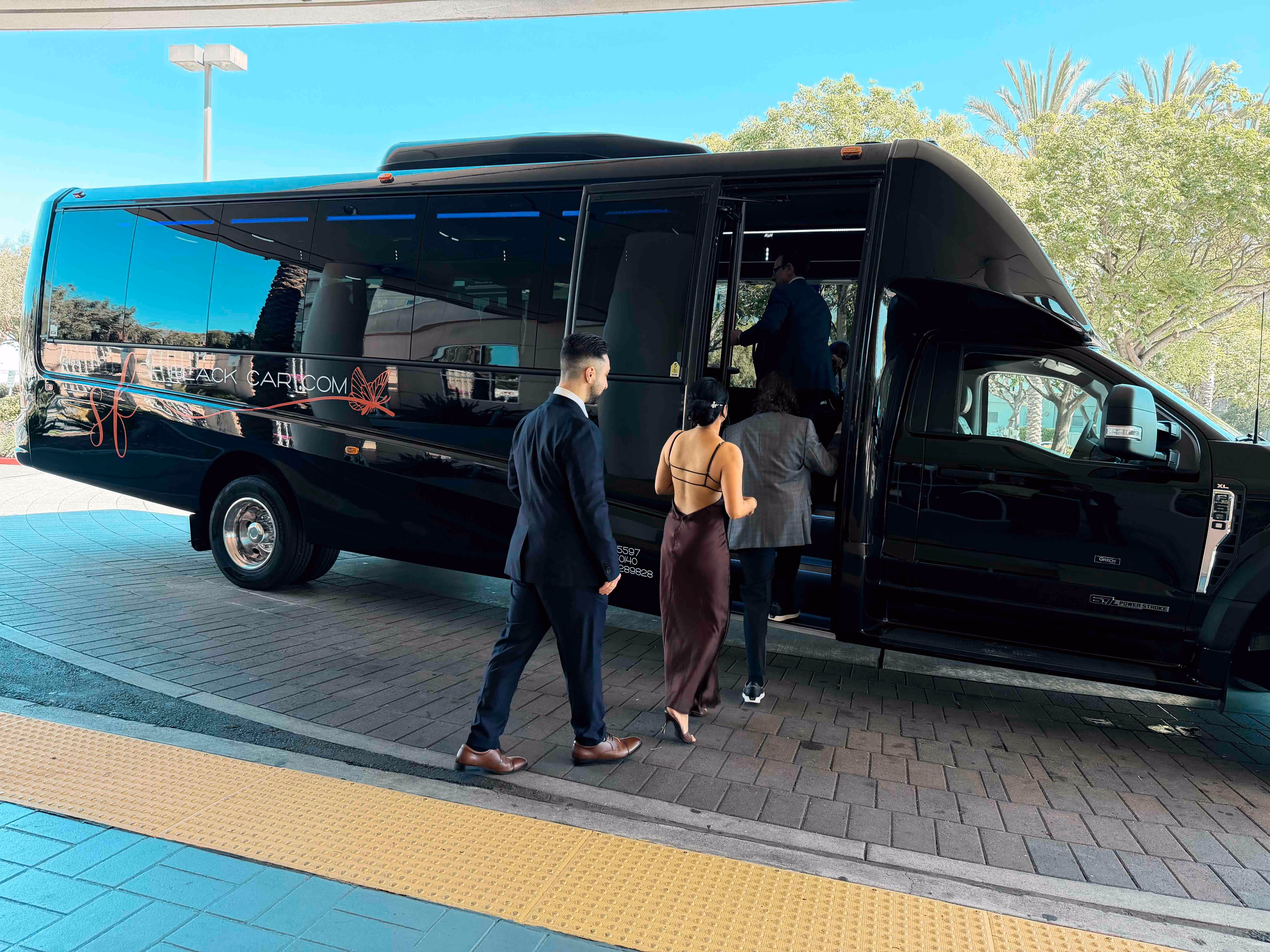 Black SF Black Car mini coach bus parked on a paved lot