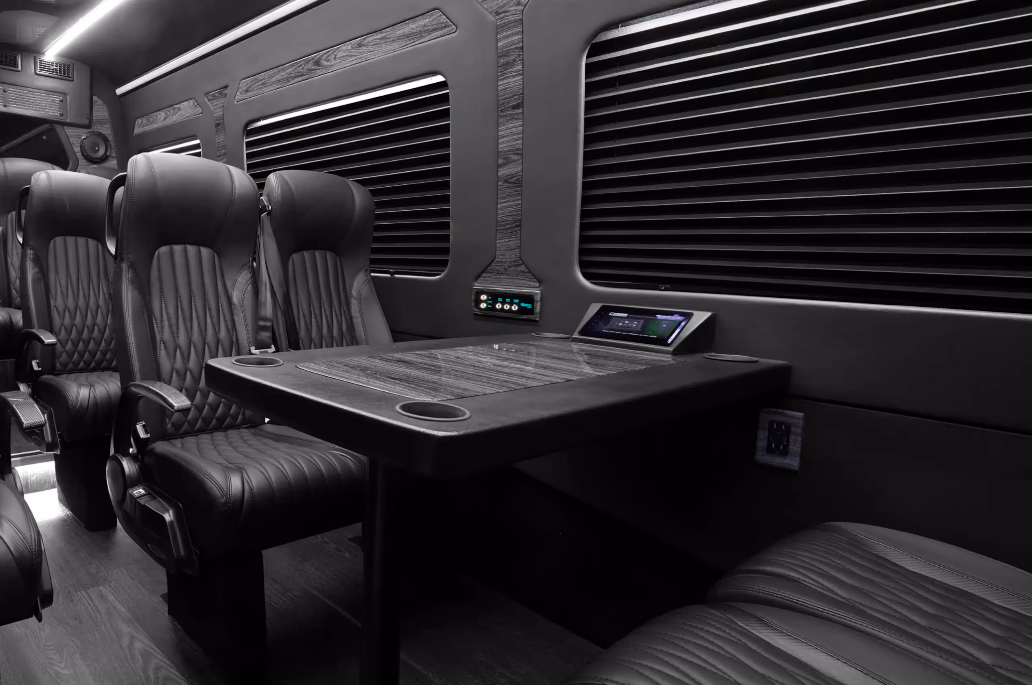 Van interior with black leather seats facing a folding table