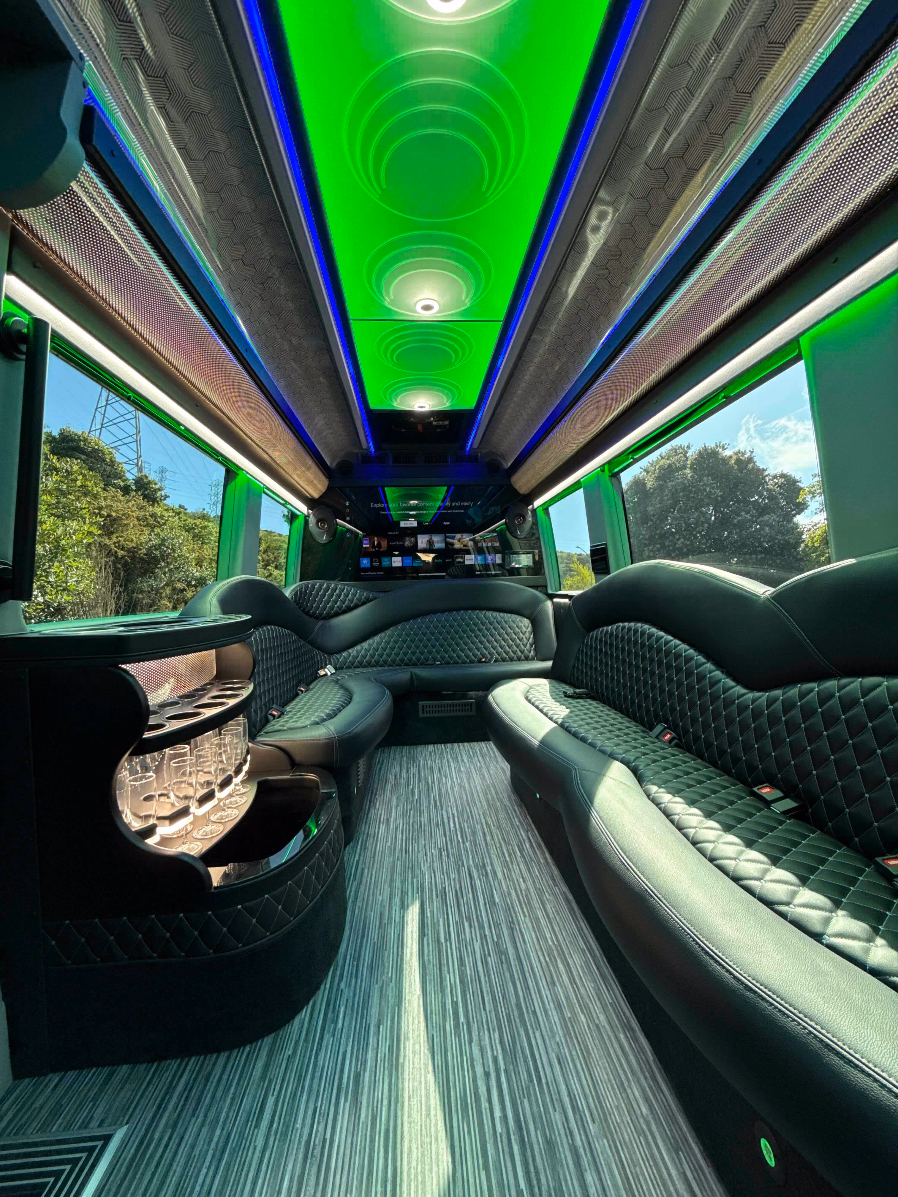Limo van interior with green leather bench seating and green LED ceiling lighting