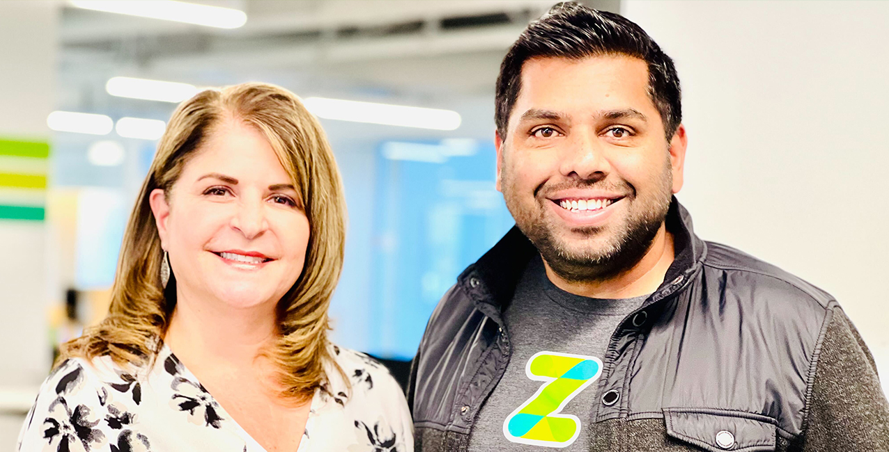 Liz Sanchez and a colleague smile in an office setting, both looking professional and approachable.