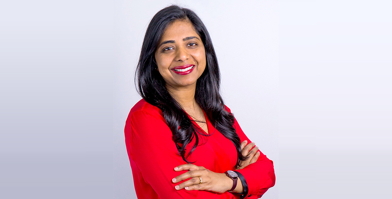 Ritu Narayan, CEO of Zum, smiling with arms crossed, wearing a red blouse against a light