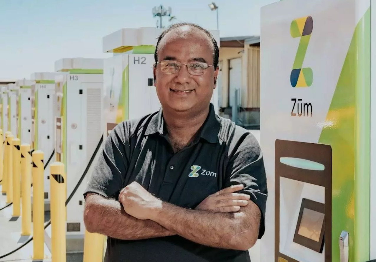 Pallav Prakash, Zum EV Program Manager, stands confidently at an EV charging station.