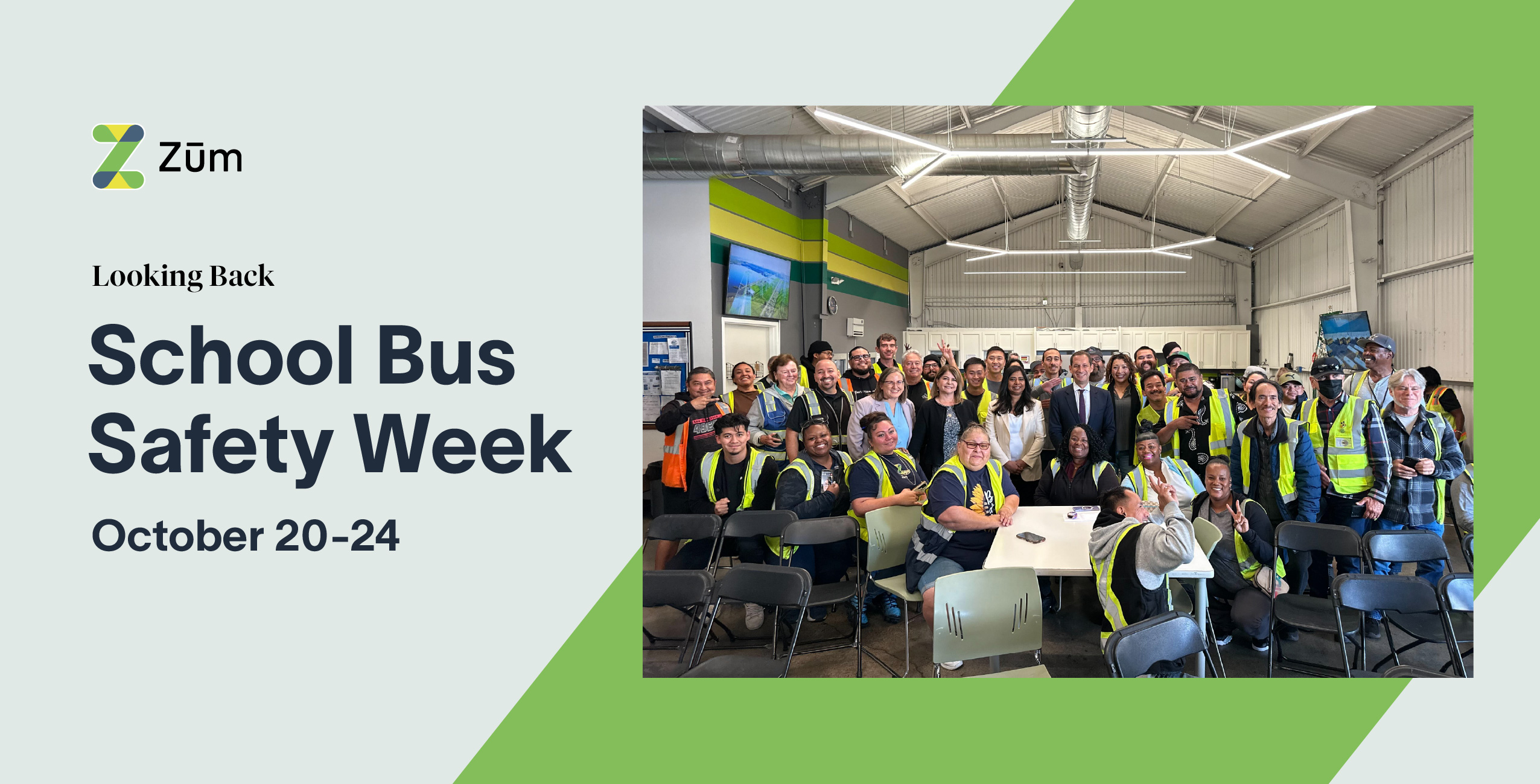 Zum drivers and staff gather for School Bus Safety Week, wearing safety vests in a bus yard setting.