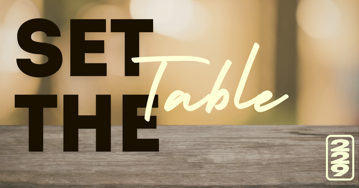 Text 'SET THE Table' over a wooden surface with a blurred warm-toned background.