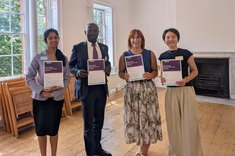  Dr. Wei Kang, Frank Nyame-Asiamah, Sreya Menon Dileepan and Eve Calderbank standing together holding The Female Entrepreneurship Report. 