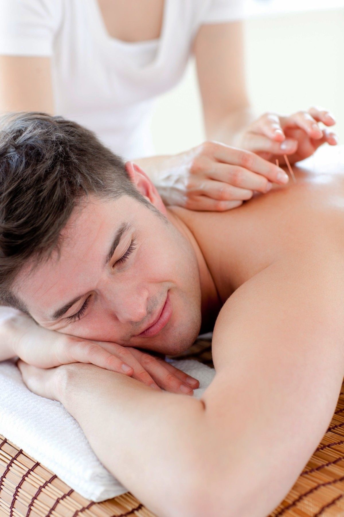 Man receiving relaxing back massage from therapist in spa setting