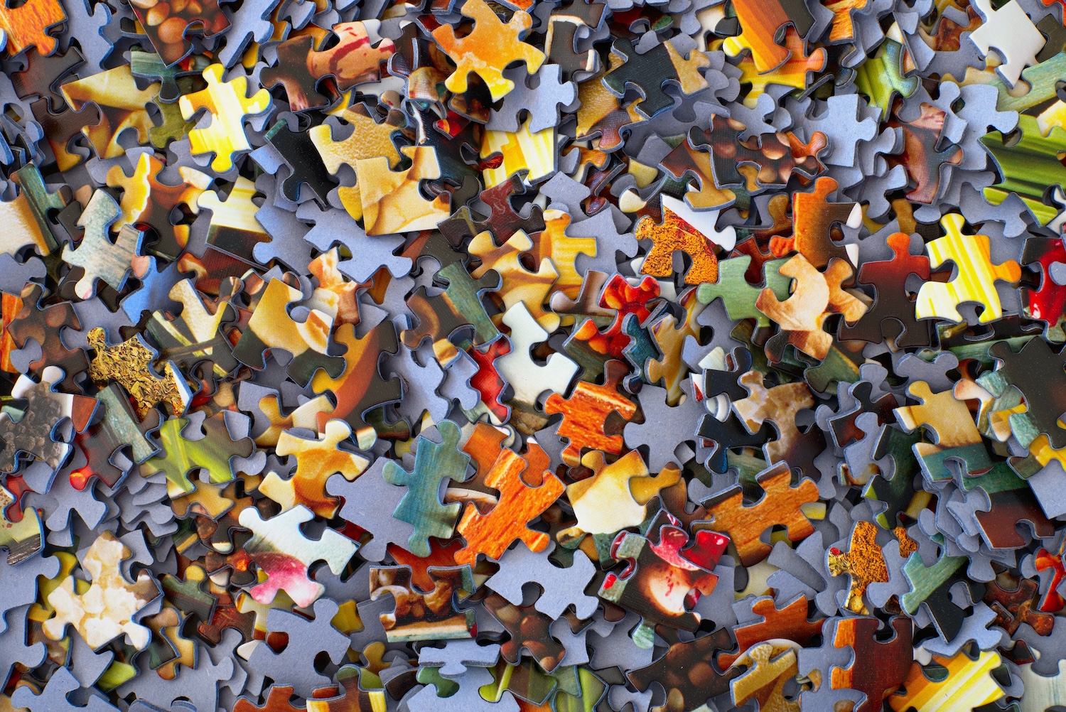 Scattered puzzle pieces with colorful autumn landscape imagery on purple background