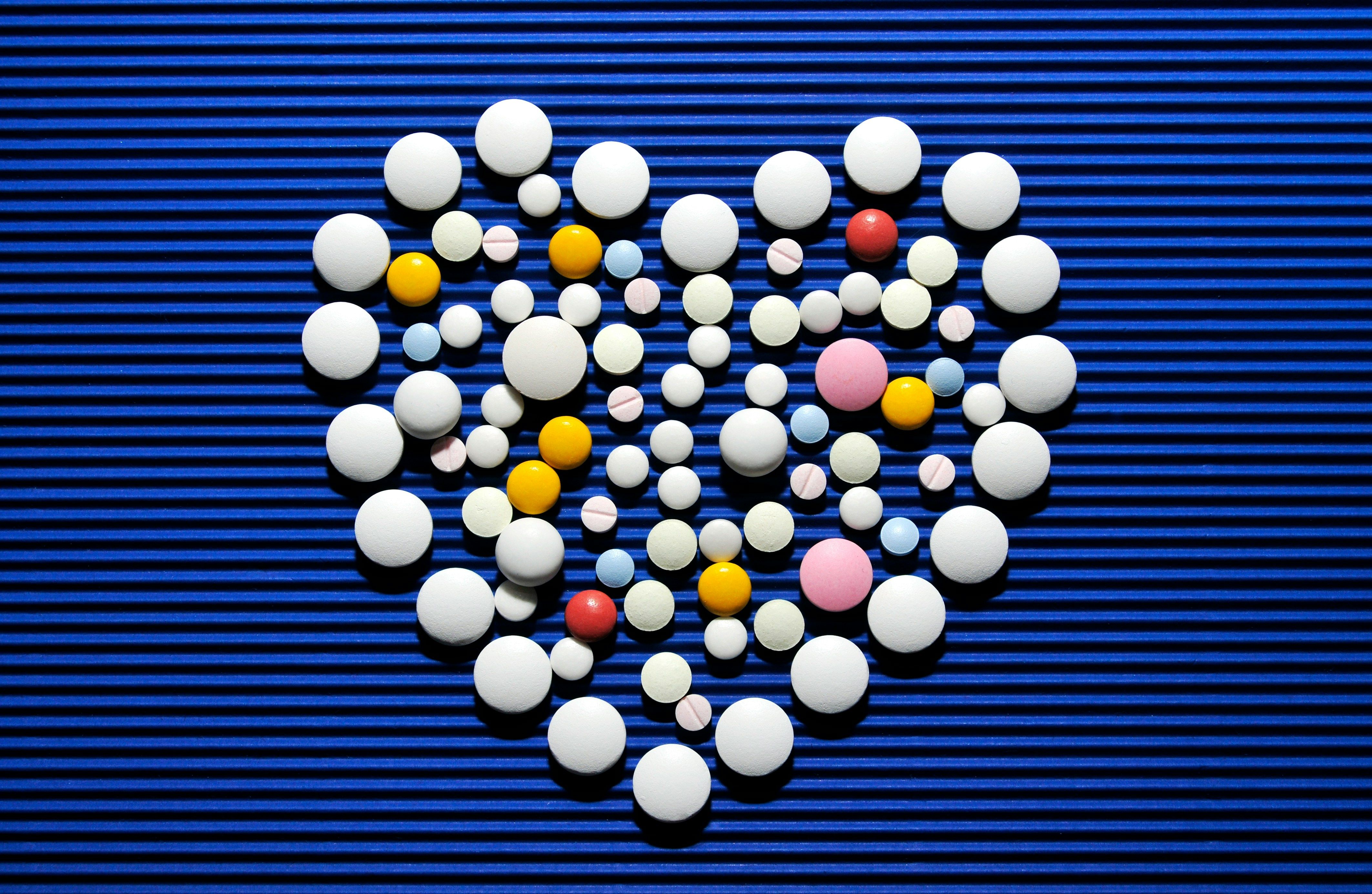 Heart shape formed by colorful 3D spheres on blue striped background