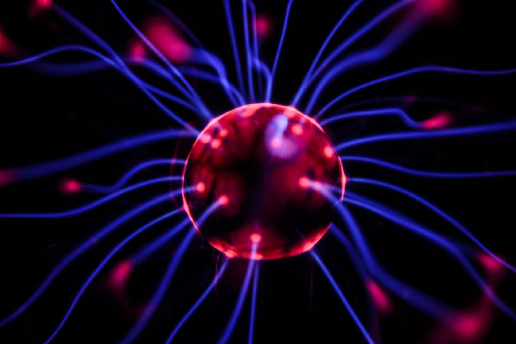 Glowing red sphere with blue energy lines radiating outward on black background