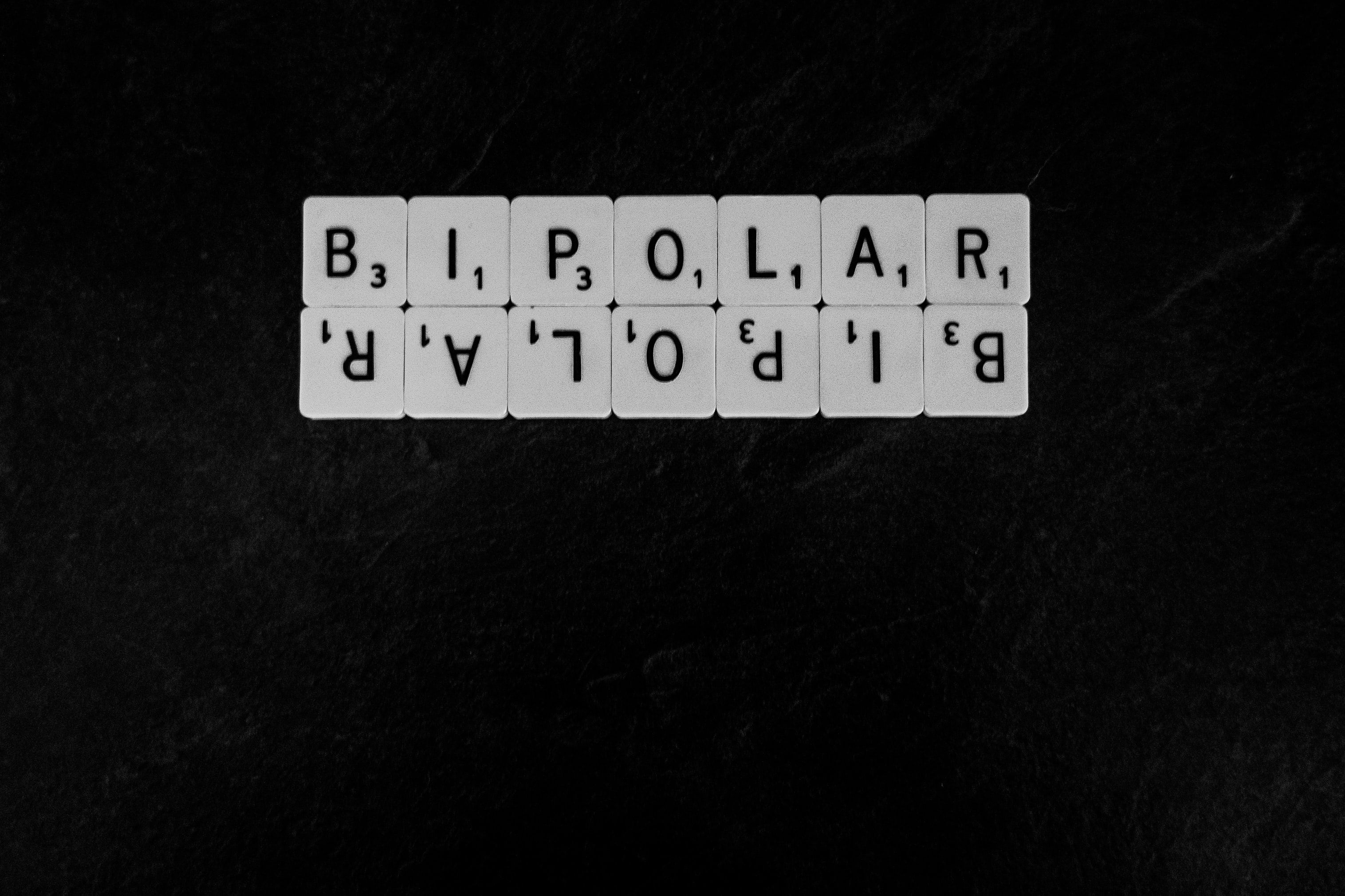 Scrabble tiles spelling BIPOLAR with point values on dark background