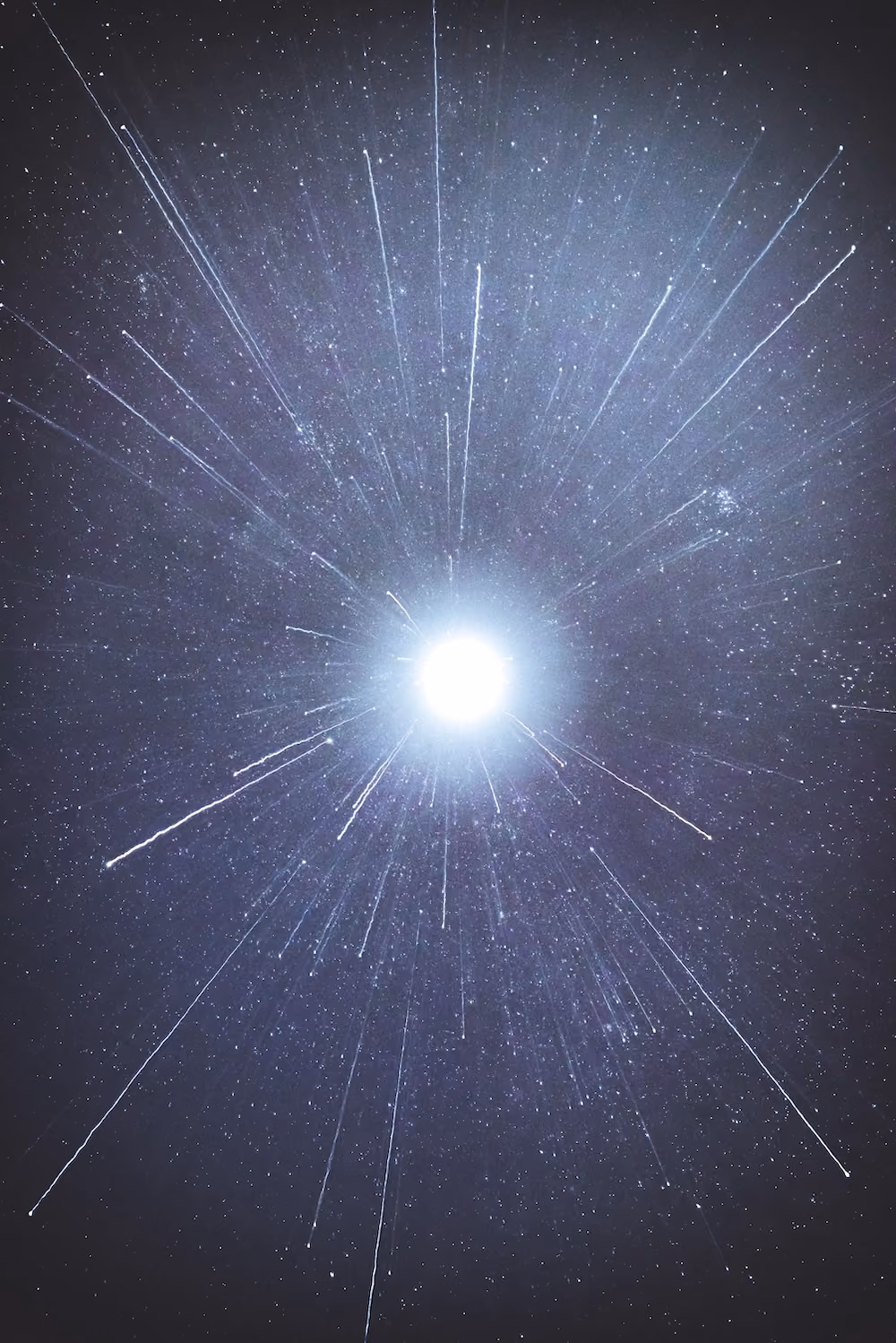 Bright star with radiating light rays and particles against starry night sky