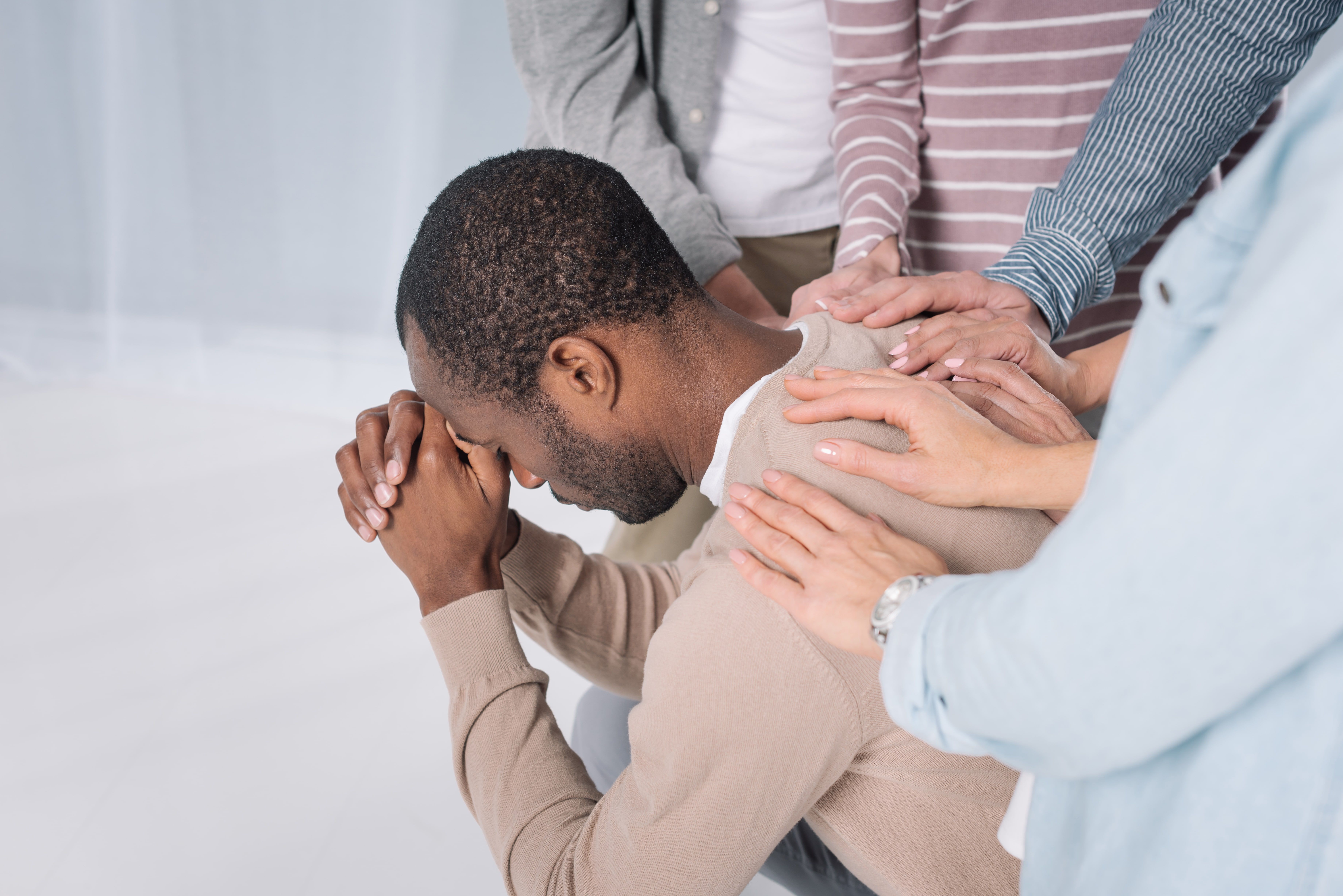 Group of people placing hands together in unity and support circle