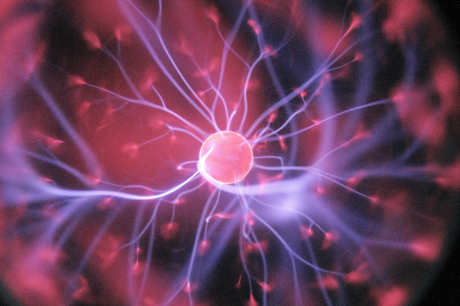 Glowing pink and purple sphere with radiating electric filaments and energy particles