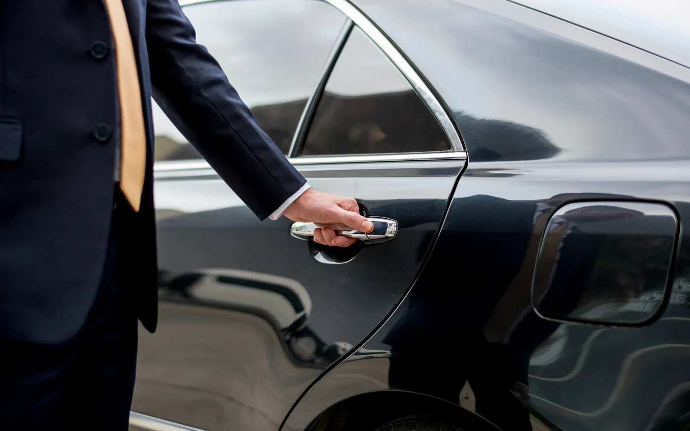 Businessman stepping into a chauffeured car