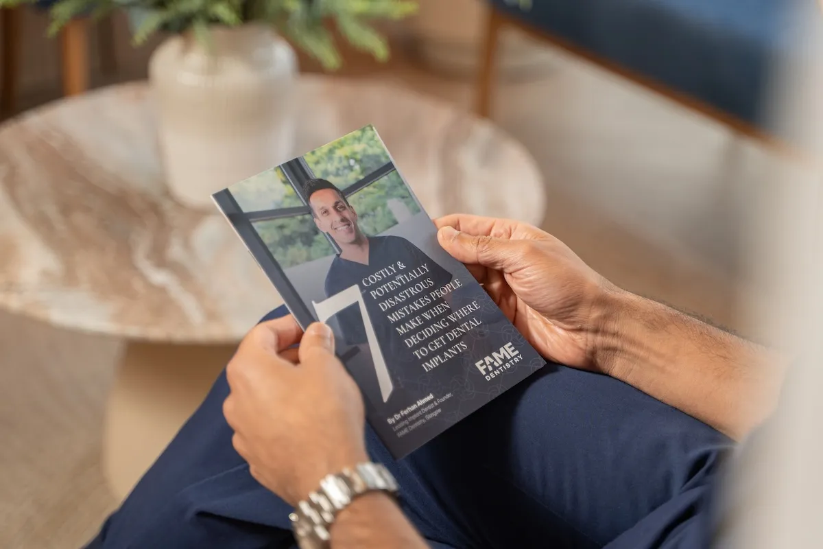 Hands holding the guide '7 Costly & Potentially Disastrous Mistakes' by Dr Ferhan Ahmed
