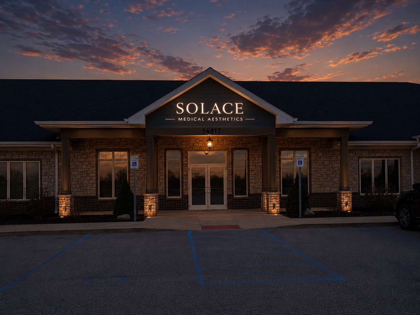 Exterior of Solace Medical Aesthetics building lit at dusk with a cloudy sky backdrop.
