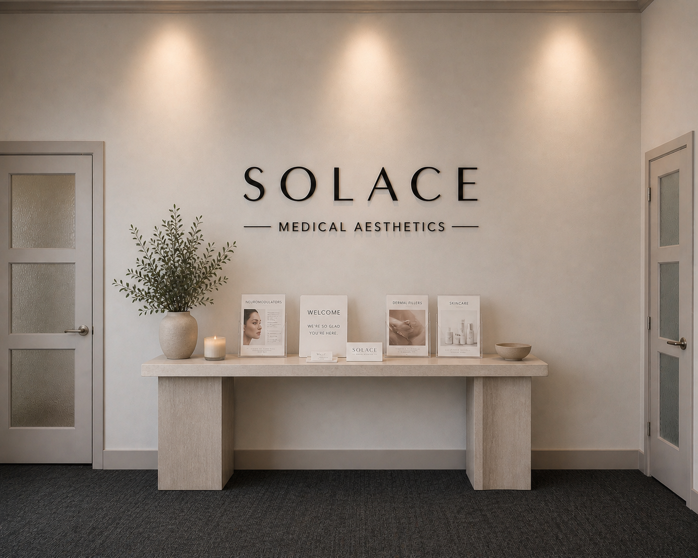Reception area with a table, decorative plant, candle, brochures, and 'Solace Medical Aesthetics' sign on wall.