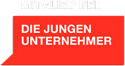 Rotes Schild mit weißer Aufschrift 'Die Jungen Unternehmer' und 'Mitglied bei!' in Großbuchstaben.
