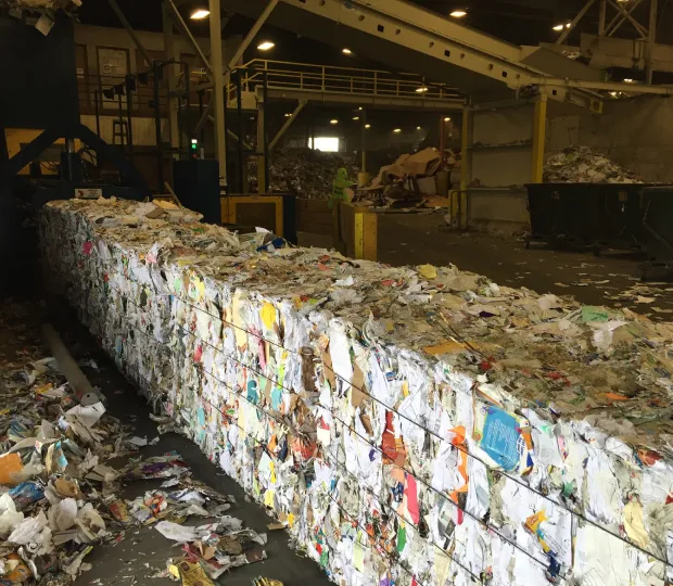 Large bales of compressed mixed paper recyclables inside a material recovery facility.