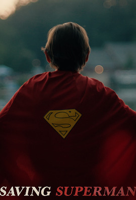 Child wearing a red cape with the Superman logo on the back at dusk.