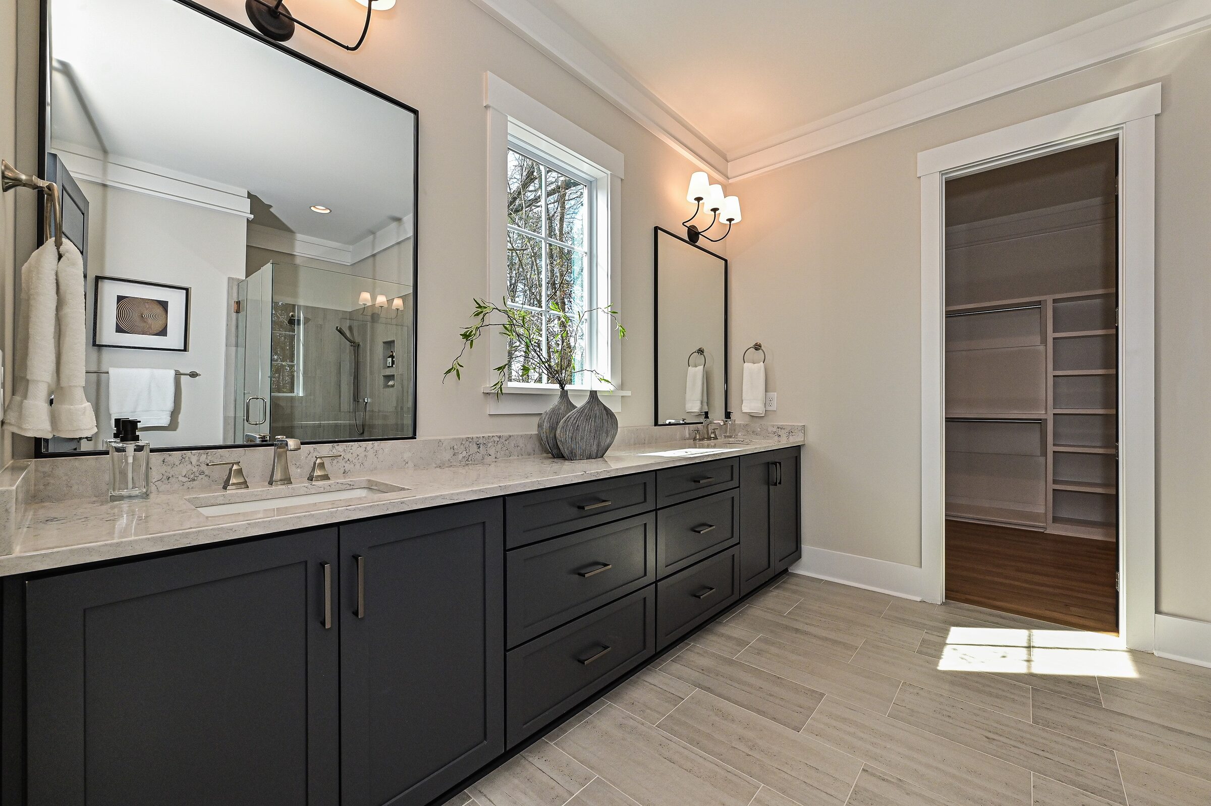 Primary bathroom with dark double vanity and quartz counters in a Charlotte custom home