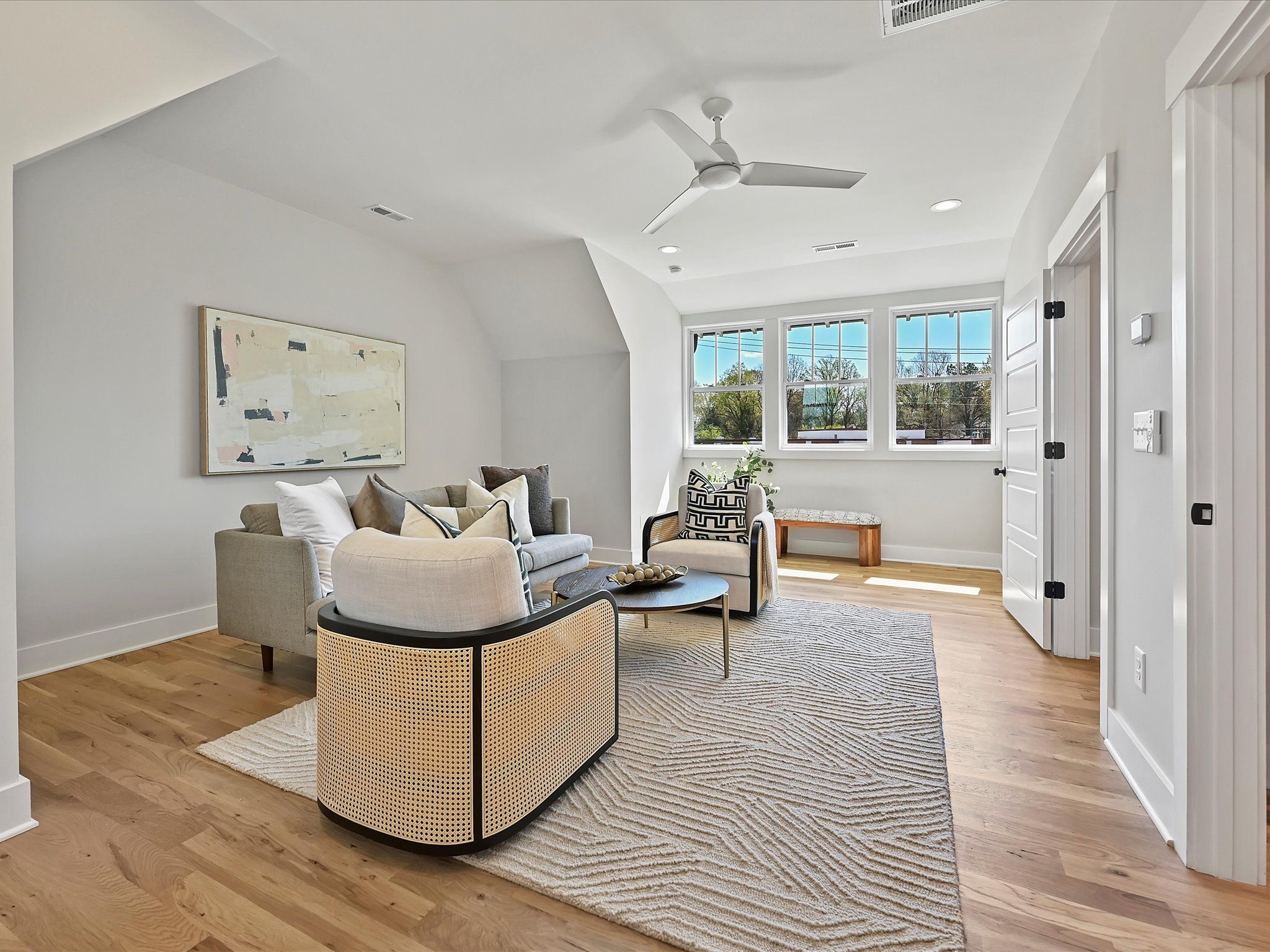 Upstairs bonus room with a sloped ceiling, a row of windows, and a seating area