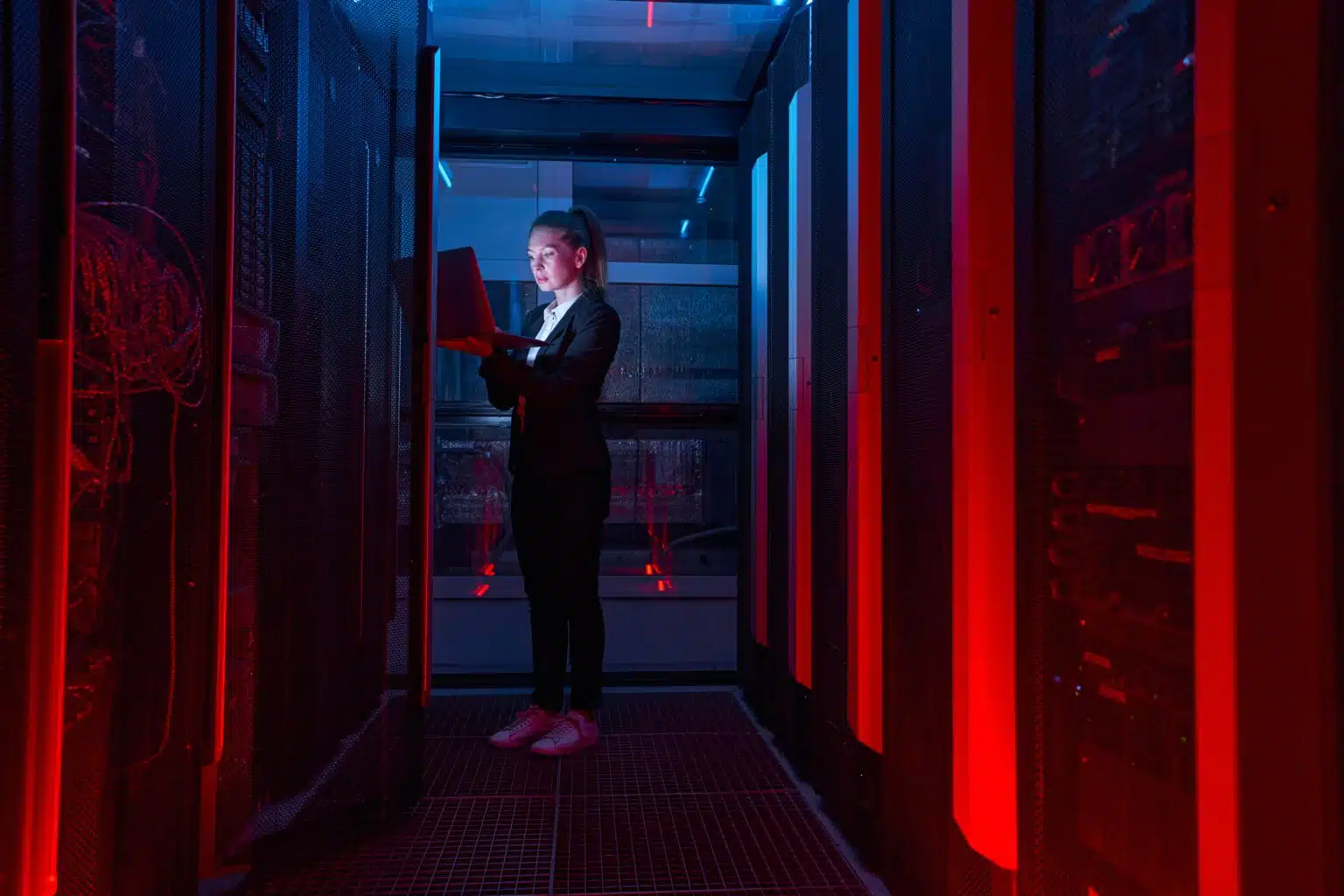 Woman analyzinc computer on a data center