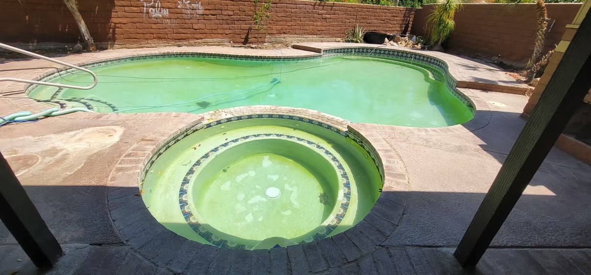 Pool and spa with algae before a remodel