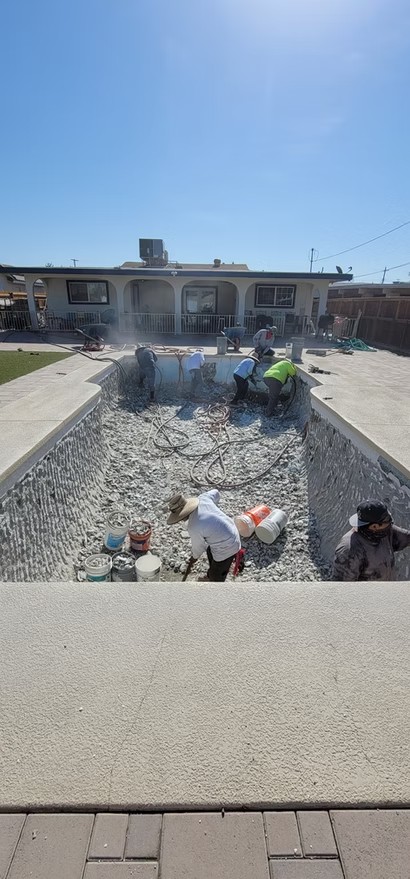 Crew removing old plaster from a pool before resurfacing