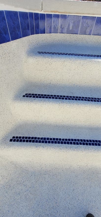 Pebble-finish pool steps with blue tile