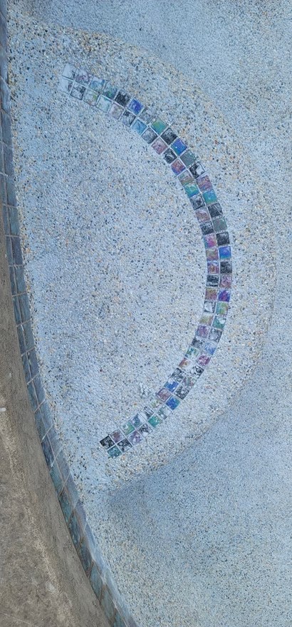 Colored accent tile installed along pool steps