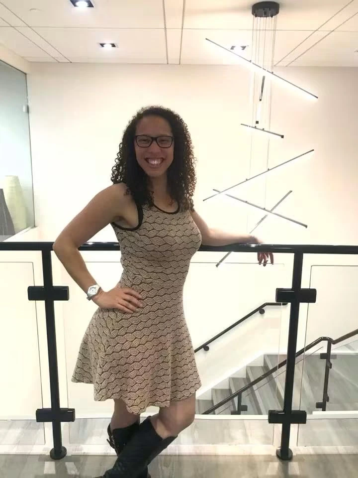 Smiling woman with curly hair and glasses