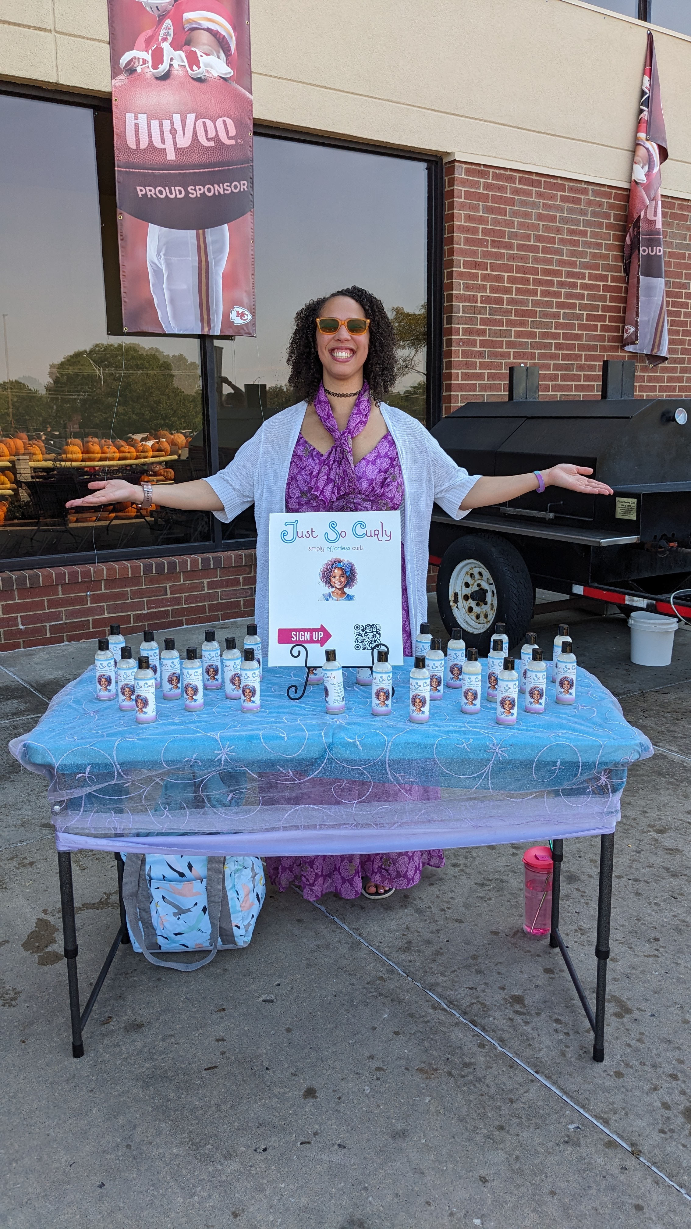 Cassandra, founder of Just So Curly, standing with her products at the brand's first pop-up event at Hy-Vee.