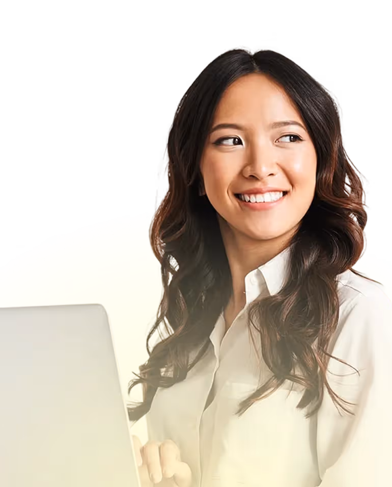 Smiling woman with long dark hair using a laptop and looking to the side on a pale yellow background.