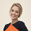 Smiling woman with short blonde hair wearing a black and orange top.