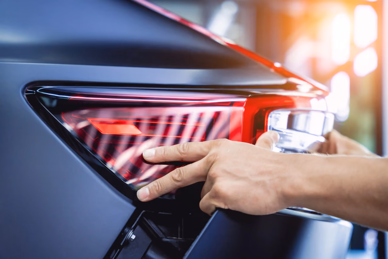 Hand checking a car tail light during a mobile vehicle inspection
