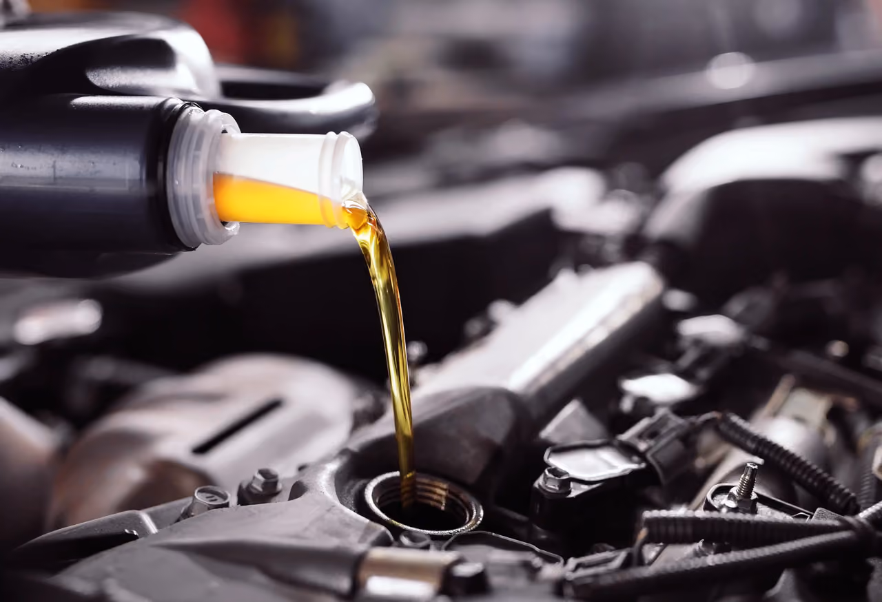 Fresh oil being poured into an engine during a mobile oil change