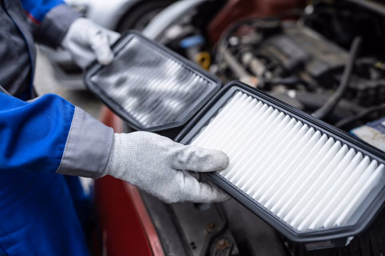 Mechanic fitting a new air filter during a mobile car service