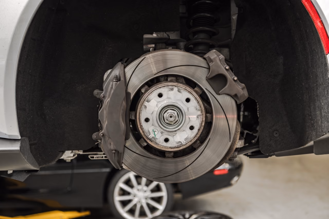 Brake disc and caliper exposed on a car wheel hub during a brake repair