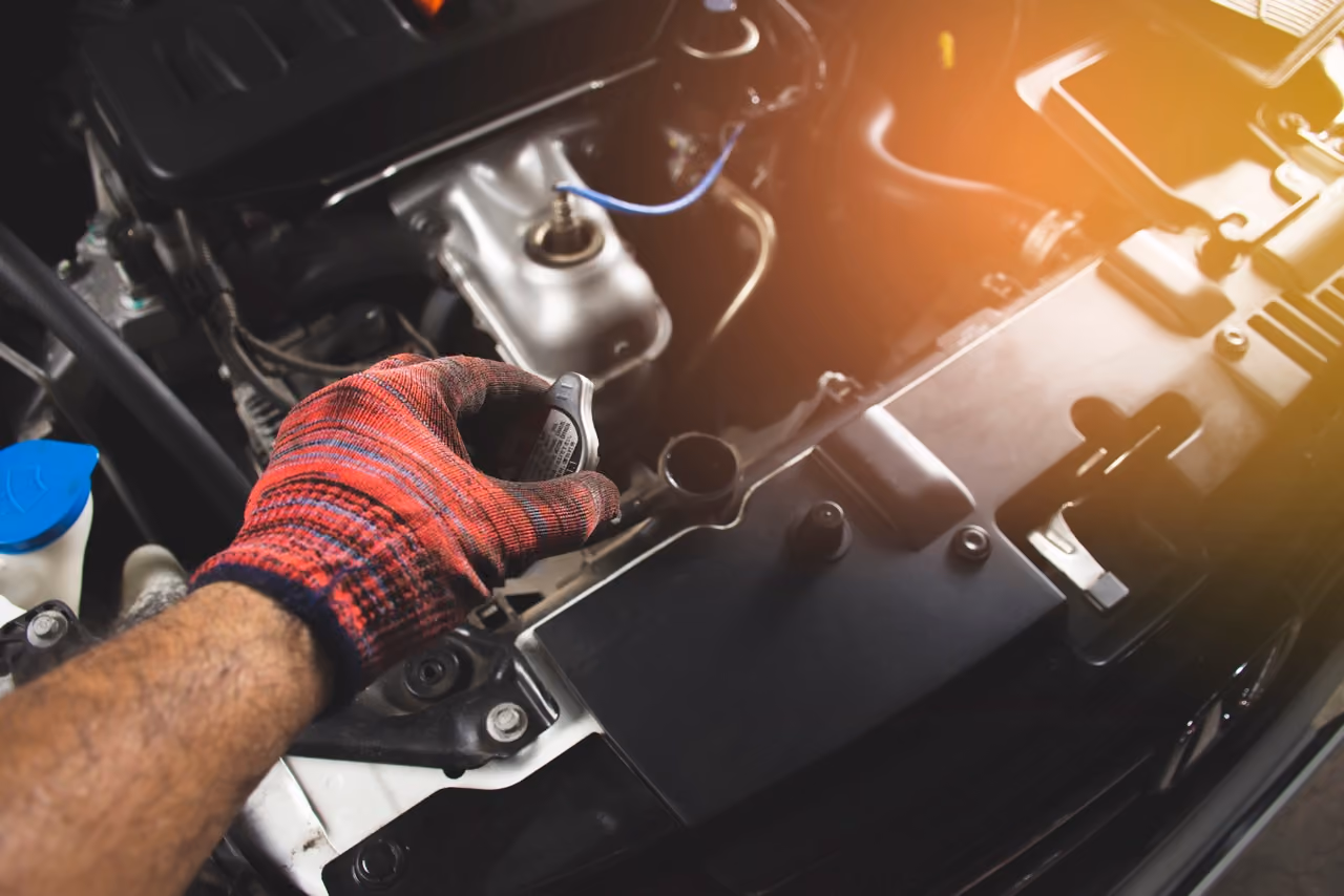 Mechanic working on a car cooling system under the bonnet